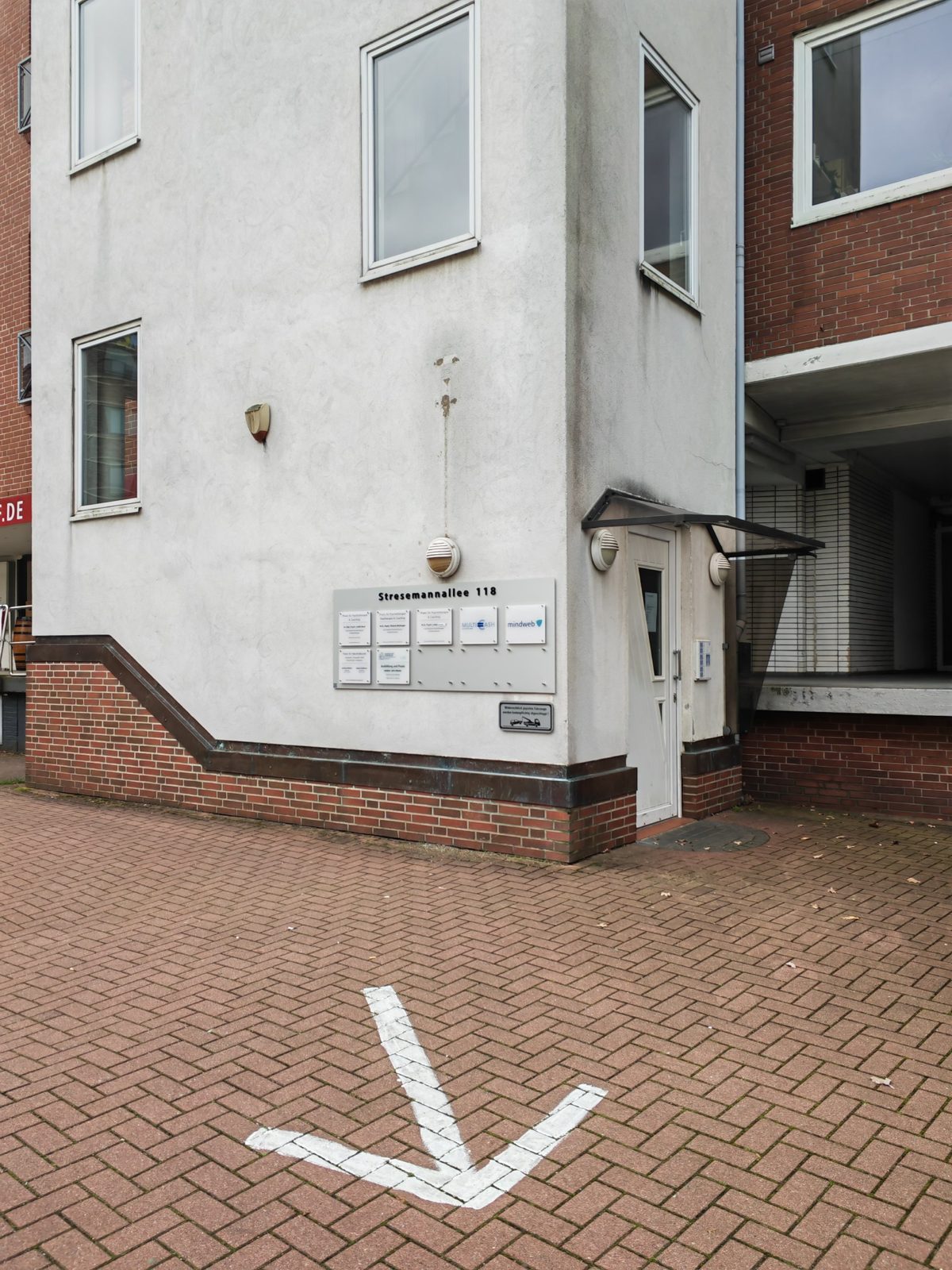 Der Eingang des Hauses Stresemannallee 118 mit einem weißen Pfeil auf dem Pflaster