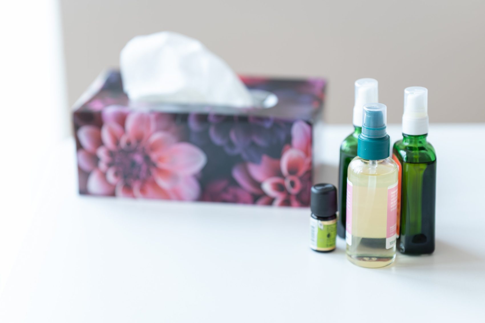Pflegeöle und Taschentuchbox auf weißem Tisch